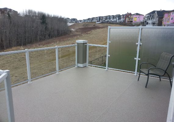 White metal and glass railings with a wind break and our vinyl decking.
