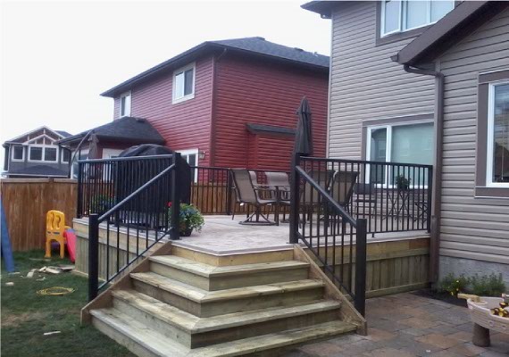 Wood deck with black metal railings and corner wrapped stairs.